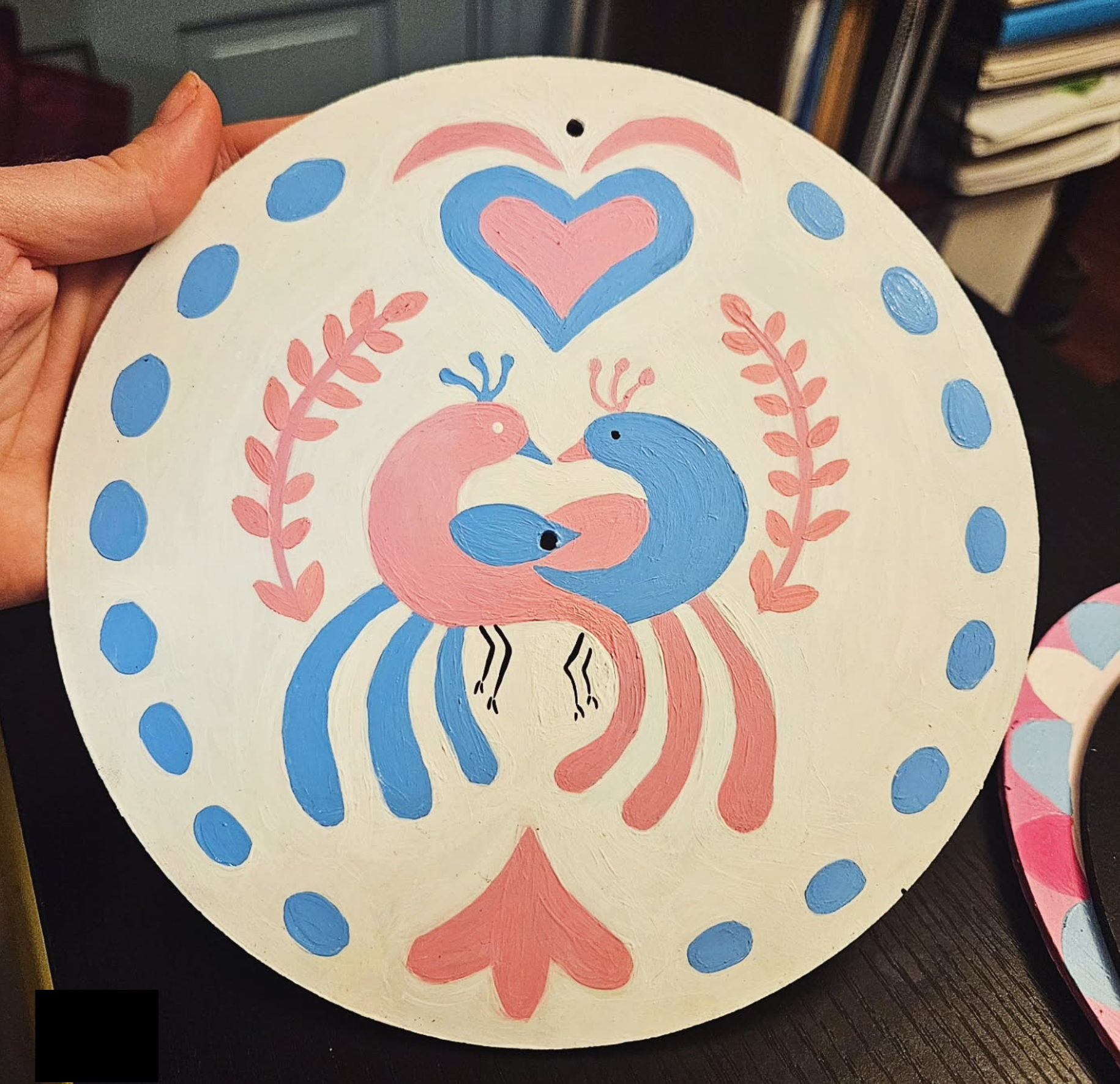 a hex with two entangled birds in trans pride colors